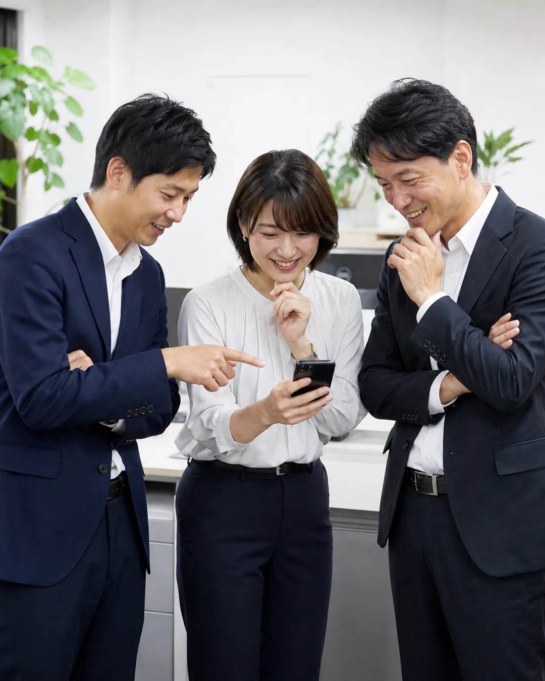 スマホの画面を見ながら話す営業チーム